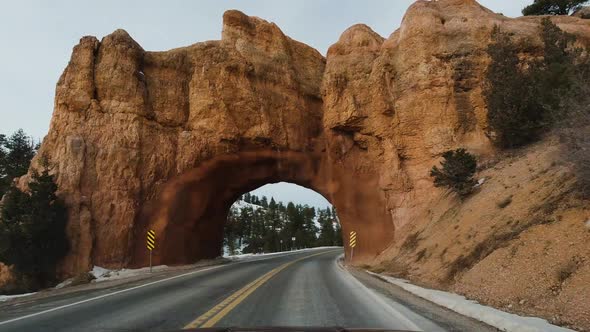 Car Driving on Road Through Red Canyon on Winter Day. Utah, USA