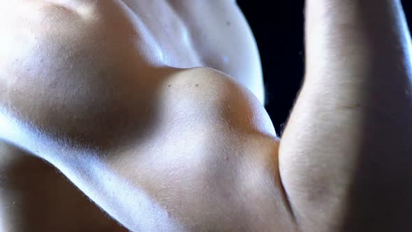 Pumped Up Biceps on a Young Man's Hand on Black Background