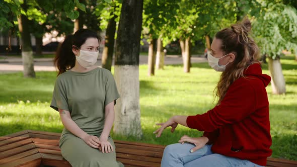 Young Pretty Girls Talk To Each Other in Protective Masks From the Coronovirus and Laughting. Daily