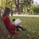 Woman is Reading Book under the Tree in the Park - VideoHive Item for Sale