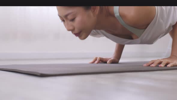 Yoga  Handstand Posture, Vrischikasana on mat, Asian woman in sportswear working out inside.