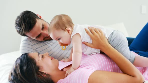 Parents playing with their baby girl in bedroom