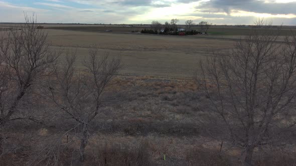 An aerial dolly pan over trees on a dry farm near Sterling Colorado 2021.