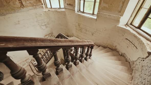 A Staircase with a Dark Wooden Railings in an Abandoned Architectural Building