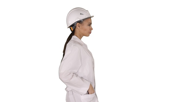 Woman in White Robe Putting Hard Hat on While Walking On