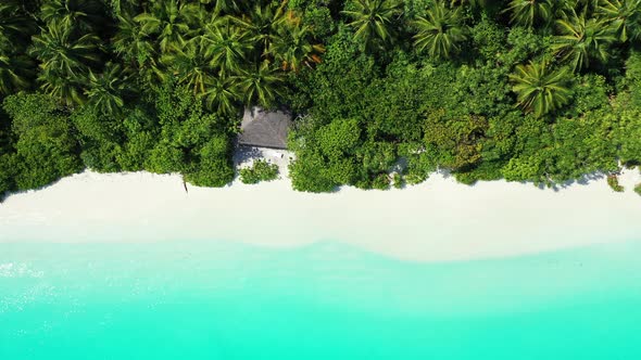 Daytime above copy space shot of a white paradise beach and blue sea background in 4K