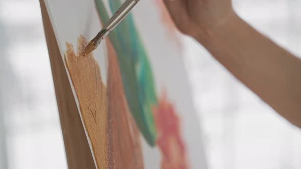 Woman Draws Lush Tropical Plant on White Canvas in Studio