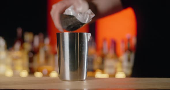 Barman Adds Ice Cubes to the Shaker in Slow Motion Bartender Mixes Cocktails on the Bar Counter 120