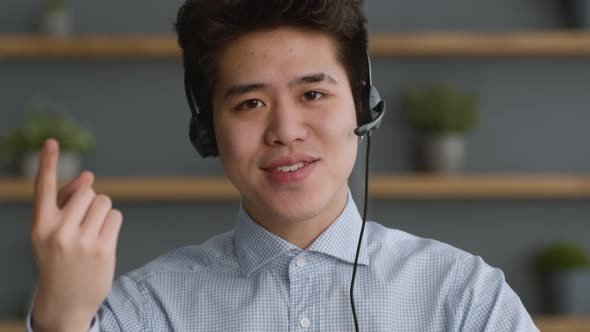 Portrait of Young Confident Asian Guy Wearing Headset Talking to Camera Explaining Basics of Online