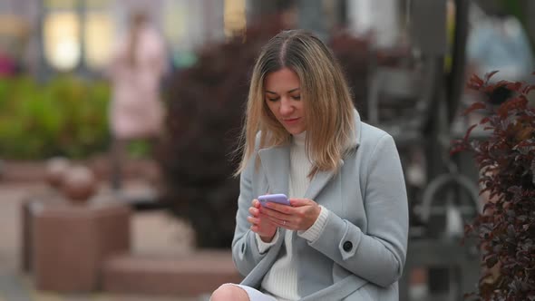 happy girl Using Mobile Phon on city street.