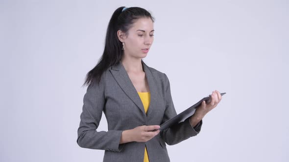 Stressed Young Businesswoman Showing Clipboard and Giving Thumbs Down