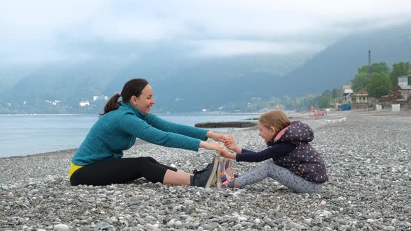 Little Girl with Mother Stretching at Seashore