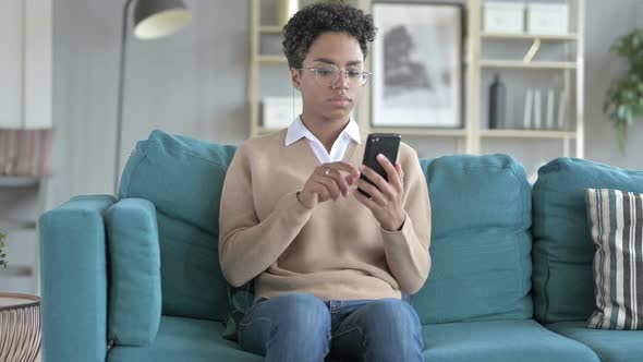 African Girl Using Phone While Sitting on Couch