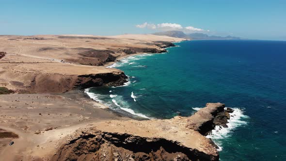 Aerial drone shot of the La Pared beach in Fuerteventura on a sunny day. Majestic cliffs and the Atl