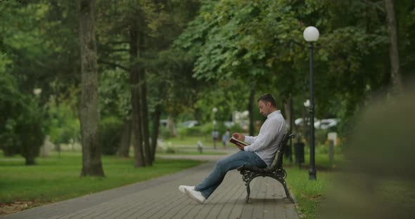 A Young Adult With Book In The Park