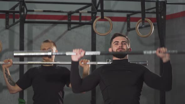Male Crossfit Athletes Warming Up at the Gym Lifting Barbells