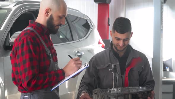 Two Professional Mechanics Repairing a Car in Car Repair Shop. Car Service, Repair and Maintenance