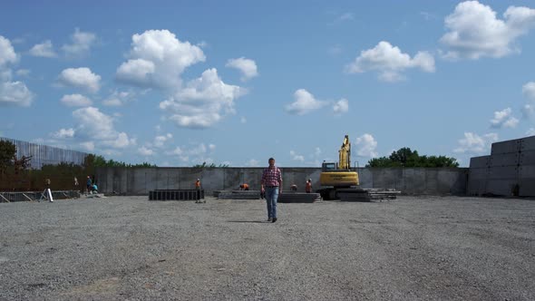 Construction Inspector Checking Build Process Walking From Yellow Excavator