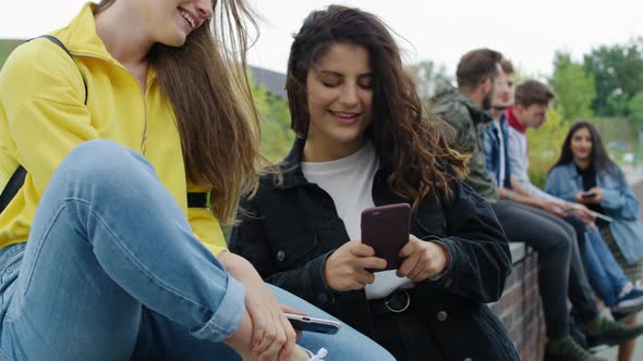 Group of young people with smart phone spending time together. Shot with RED helium camera in