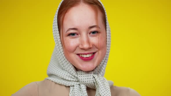Headshot of Charming Redhead Woman with Green Eyes in Kerchief Looking at Camera Smiling