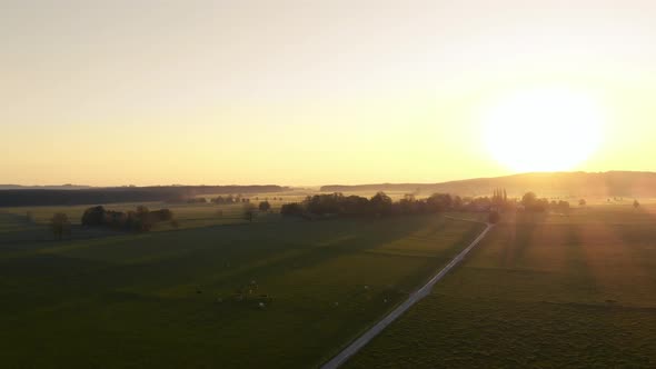 Pan over agriculture fields with the sunset over the mountains in the background, Bavaria, Germany