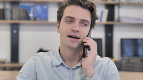 Portrait of Creative Man Talking on Phone in Office