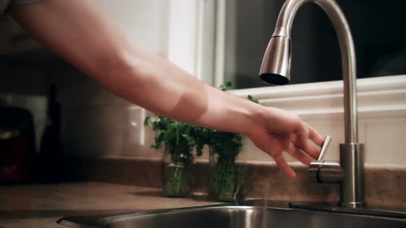 Man Filling a Glass of Water Before to go to Bed