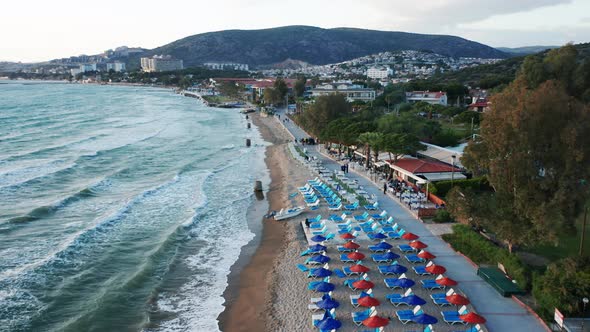 Resort on sandy beach with umbrellas at popular travel destination Kusadasi, Turkey - drone