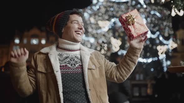 Portrait of Happy Guy Dancing in a Middle of a Square During Holiday Season at Night