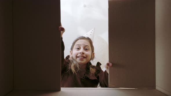 Displeased Kid Looking Inside Box with Her Birthday Gift