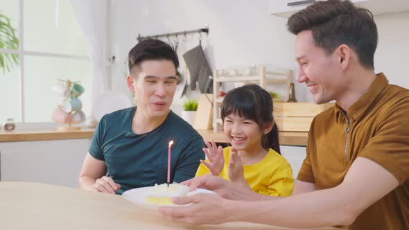 Asian attractive LGBTQ gay family celebrate birthday girl kid in house.