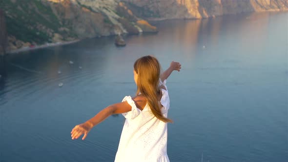 Happy Kid Outdoor on Edge of Cliff Seashore