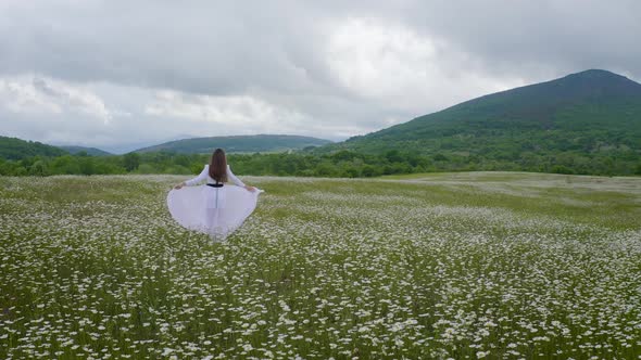 Beautiful Girl in Meadow of Camomile Flower