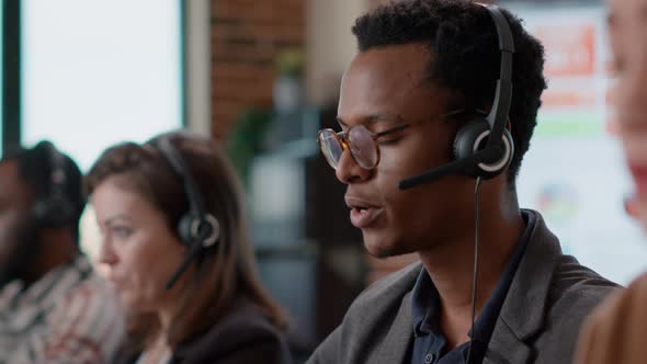 African American Worker Having Conversation on Headset with Client