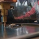 A Professional Worker Behind Protective Glass Works with a Metalworking Machine - VideoHive Item for Sale