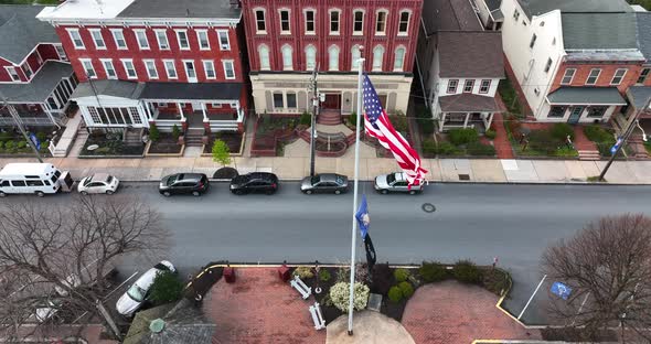 USA, Pennsylvania POW MIA flags wave in breeze. Aerial reveals town scene in spring season. Historic