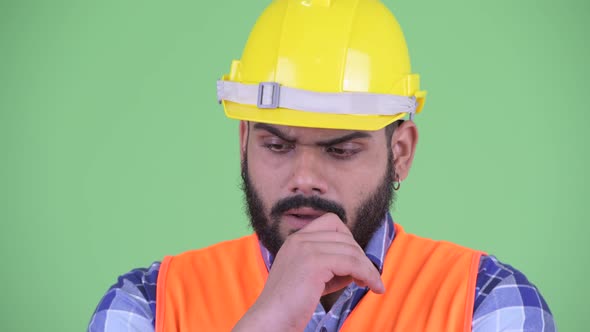 Face of Stressed Young Overweight Bearded Indian Man Construction Worker Thinking and Looking Down