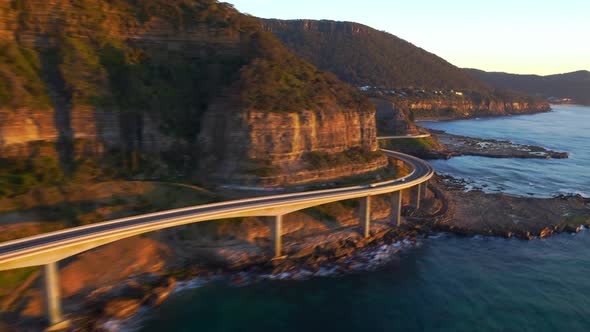 Fast forward over Curvy Sea Cliff Bridge Road, with cars driving in early Morning, NSW Australia - a