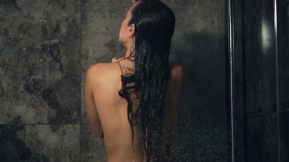 Woman Washing Hair and Showering. View from Back. Slowmotion