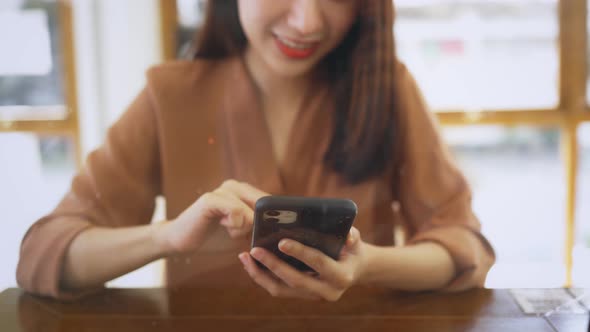 Hands of Young Woman Using Smartphone in Cafe