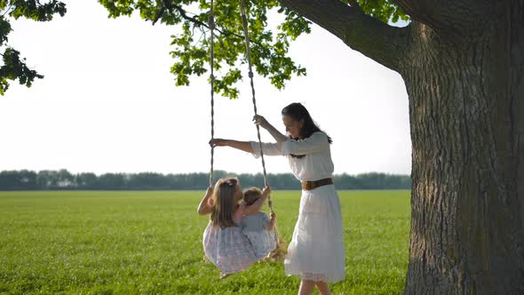 Mother Shakes Her Daughters, on a Wooden Rope Swing Tied To an Old Oak Tree.