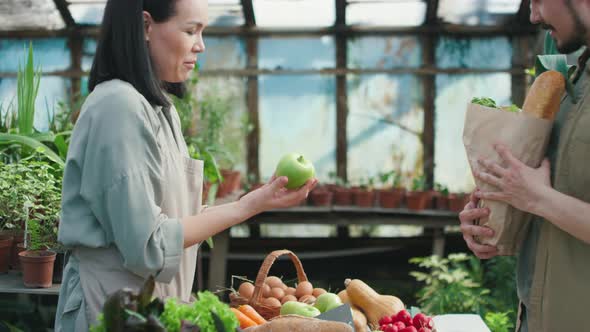 Young Female Farmer Selling Fruit to Man