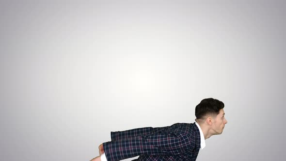Businessman Makes a Back Flip and Shows Cool Gesture To Camera After on Gradient Background.