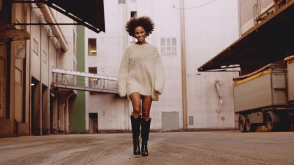 Young Woman In Woollen Top And Boots With Windswept Afro