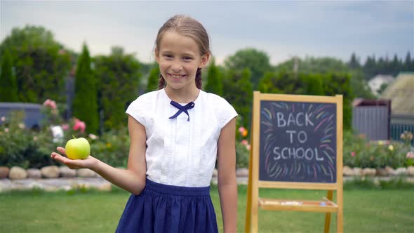 Happy Little Schoolgirl with a Chalkboard Outdoor