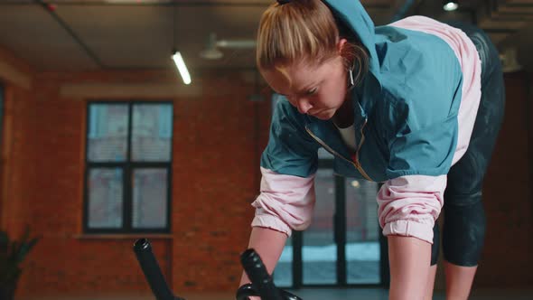 Healthy Caucasian Woman Exercising Workout on Stationary Cycling Machine Bike in Gym Slow Motion