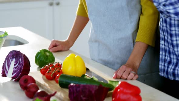 Man feeding woman in the kitchen at home