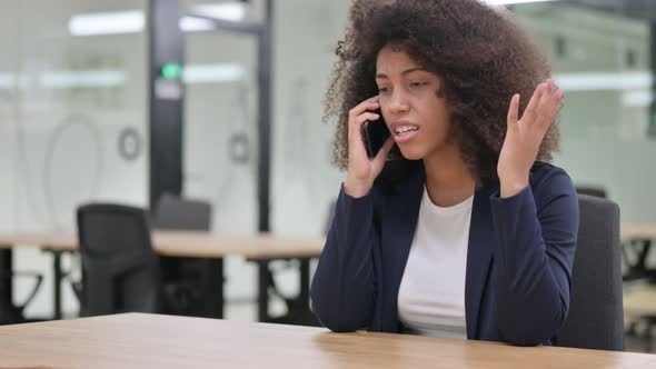 Angry Young African Businesswoman Talking on Smartphone 