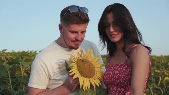 Pretty Female Artist Painting Her Man Holds a Sunflower and They Have a Fun