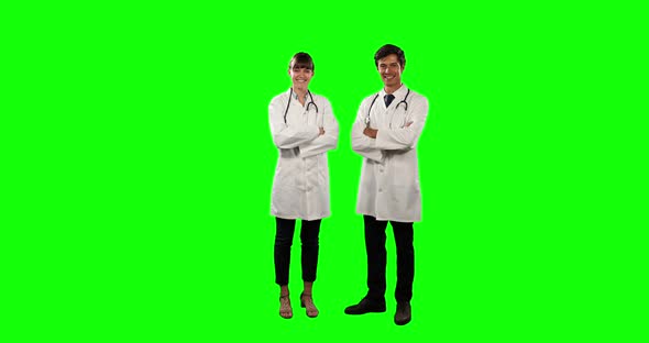 Front view of doctors smiling at camera with green screen